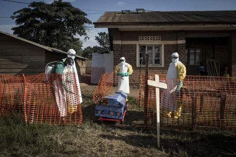 Nhân viên y tế phun thuốc khử trùng quanh quan tài của một bệnh nhân nhiễm Ebola tại Beni, CHDC Congo, ngày 13/8/2018. (Ảnh: AFP/TTXVN)