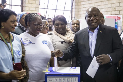 Tổng thống Nam Phi Cyril Ramaphosa (phải) đồng thời là Chủ tịch đảng Đại hội Dân tộc Phi (ANC) cầm quyền bỏ phiếu tổng tuyển cử tại điểm bầu cử ở Soweto ngày 8/5 vừa qua. (Ảnh: AFP/TTXVN)