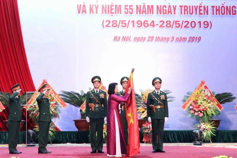 Phó Chủ tịch nước Đặng Thị Ngọc Thịnh gắn Danh hiệu Anh hùng Lực lượng Vũ trang Nhân dân lên lá cờ truyền thống của Cục Đối ngoại. (Ảnh: Văn Điệp/TTXVN)