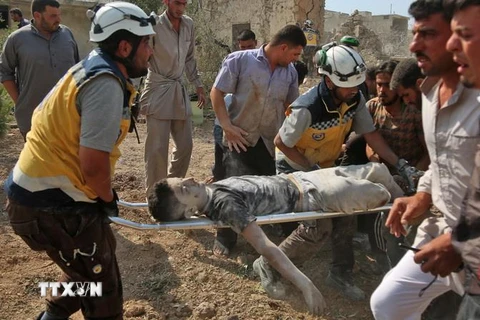 Lực lượng cứu hộ chuyển nạn nhân bị thương sau một cuộc không kích tại làng Babuline, gần thị trấn Khan Shaykhun, tỉnh Idlib, Syria, ngày 7/6 vừa qua. (Ảnh: AFP/TTXVN)