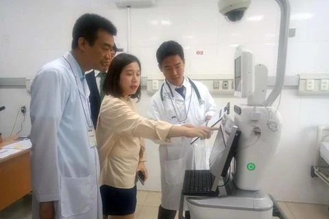 Chuyên gia Nhật Bản giới thiệu, hướng dẫn sử dụng robot chăm sóc tại buồng bệnh. (Ảnh: Hoàng Ngọc/TTXVN)