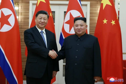 Nhà lãnh đạo Triều Tiên Kim Jong-un (phải) trong cuộc gặp Chủ tịch Trung Quốc Tập Cận Bình (trái) đang có chuyến thăm Bình Nhưỡng ngày 20/6 vừa qua. (Ảnh: Yonhap/TTXVN)