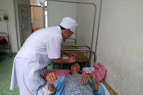 Bác sỹ bệnh viện đa khoa huyện Quan Sơn khám cho bệnh nhân Hoàng Xuân Luyến, 45 tuổi. (Ảnh: Nguyễn Nam/TTXVN)