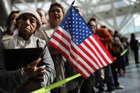 Một người mẹ chờ đợi con trai rời khỏi một buổi lễ nhập tịch, tại Los Angeles của bang California. (Nguồn: Getty Images)