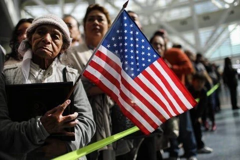 Một người mẹ chờ đợi con trai rời khỏi một buổi lễ nhập tịch, tại Los Angeles của bang California. (Nguồn: Getty Images)