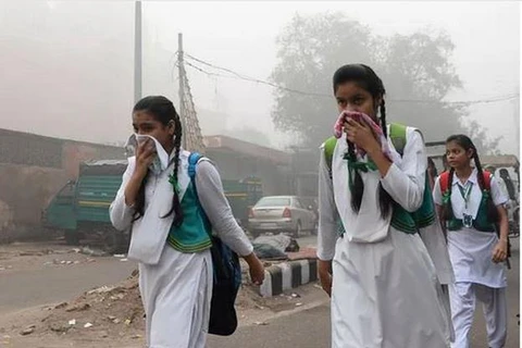 Học sinh Ấn Độ che mặt khi đi bộ đến trường giữa sương khói nặng nề ở New Delhi. (Nguồn: AFP/Getty Images)