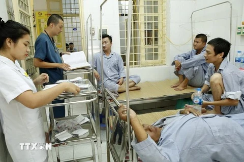 Nhân viên y tế chăm sóc điều trị cho người bệnh mắc sốt xuất huyết tại khoa Truyền nhiễm-bệnh viện Đa khoa Đống Đa. (Ảnh: Dương Ngọc/TTXVN)