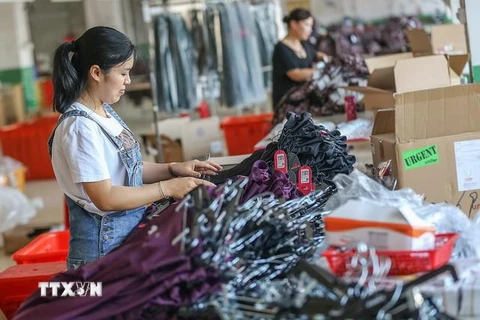 Công nhân làm việc trong một nhà máy dệt may ở tỉnh Phúc Kiến của Trung Quốc. (Ảnh: AFP/TTXVN)