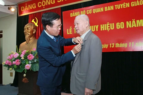 Trưởng Ban Tuyên giáo Trung ương Võ Văn Thưởng gắn Huy hiệu 60 năm tuổi Đảng cho đồng chí Lê Xuân Tùng. (Ảnh: Doãn Tấn/TTXVN)