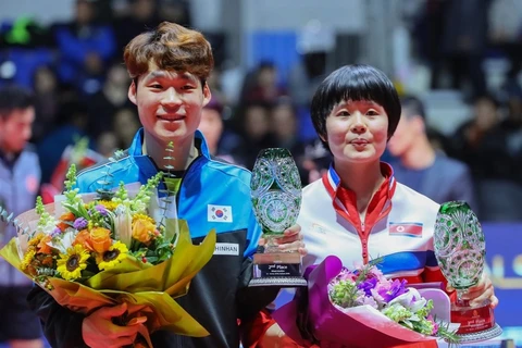 Vận động viên Jang Woo-jin của Hàn Quốc và Cha Hyo-sim của Triều Tiên giương cao chiếc cúp hạng hai của họ trong đôi nam nữ trong lễ trao giải tại Liên đoàn bóng bàn quốc tế World Tour Grand Finals tại Namdong Gymnasium ở Incheon, cách Seoul 40km về phía 