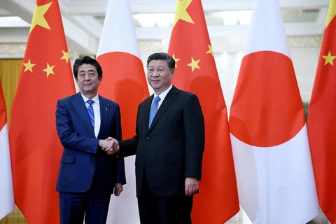Chủ tịch Trung Quốc Tập Cận Bình (phải) trong cuộc gặp Thủ tướng Nhật Bản Shinzo Abe tại Bắc Kinh ngày 23/12. (Ảnh: AFP/TTXVN)