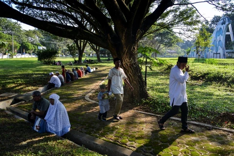 Người dân tập trung tại nghĩa trang quận Aceh Besar, tỉnh Aceh ở Indonesia ngày 26/12, để tưởng niệm các nạn nhân thiệt mạng trong thảm họa động đất-sóng thần 15 năm trước. (Ảnh: AFP/TTXVN)