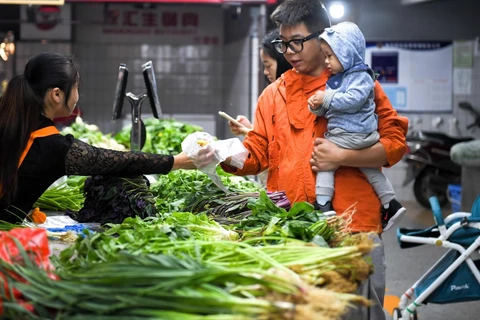 Người dân mua bán tại chợ ở tỉnh Hồ Nam, Trung Quốc. (Ảnh: THX/TTXVN)
