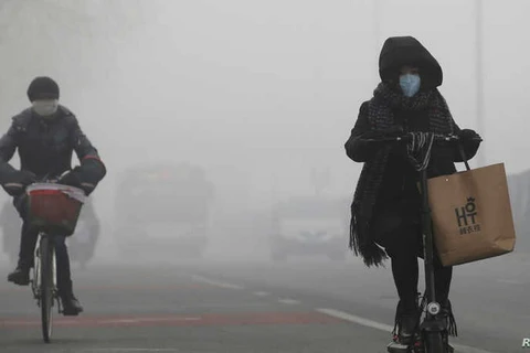 Mọi người đi xe giữa sương khói ở Bắc Kinh của Trung Quốc. (Nguồn: Reuters)