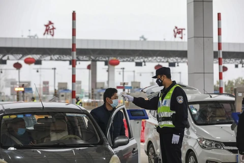 Kiểm tra thân nhiệt của lái xe trên tuyến đường cao tốc ở Vũ Hán, tỉnh Hồ Bắc, Trung Quốc, ngày 24/1. (Ảnh: AFP/TTXVN)