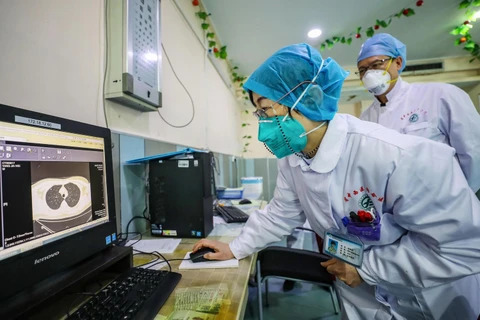 Các bác sĩ kiểm tra hình ảnh chụp CT phổi của bệnh nhân nhiễm virus corona ở bệnh viện thành phố Vũ Hán, tỉnh Hồ Bắc, Trung Quốc ngày 30/1 vừa qua. (Ảnh: AFP/TTXVN)