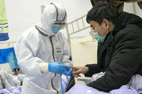 Nhân viên y tế điều trị cho bệnh nhân nhiễm COVID-19 tại bệnh viện dã chiến ở Vũ Hán, tỉnh Hồ Bắc, Trung Quốc, ngày 10/2 vừa qua. (Ảnh: THX/TTXVN)