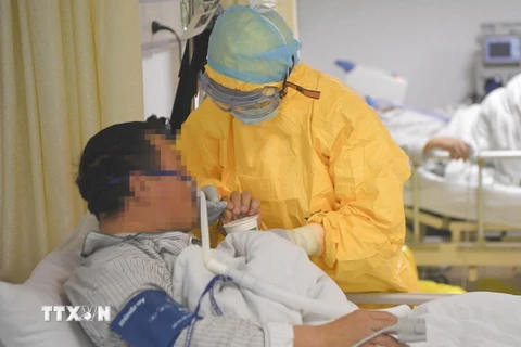 Nhân viên y tế hỗ trợ bệnh nhân nhiễm virus COVID-19 tại bệnh viện ở thành phố Trùng Khánh, Trung Quốc ngày 1/2 vừa qua. (Ảnh: THX/TTXVN)