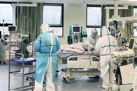Nhân viên y tế Trung Quốc điều trị cho bệnh nhân 14 tháng tuổi bị nhiễm dịch viêm đường hô hấp cấp COVID-19 tại bệnh viện dã chiến ở Vũ Hán, tỉnh Hồ Bắc. (Ảnh: THX/TTXVN)