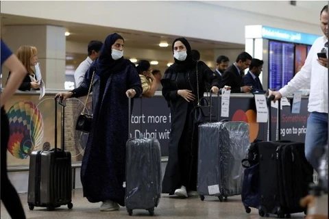 Du khách đeo mặt nạ khi đến Sân bay Quốc tế Dubai, sau khi Bộ Y tế và Phòng chống Cộng đồng của UAE xác nhận trường hợp nhiễm virus corona. (Nguồn: Reuters)