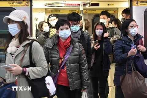 Hành khách đeo khẩu trang phòng tránh lây nhiễm COVID-19 tại một nhà ga ở Đài Bắc, Đài Loan. (Ảnh: AFP/TTXVN)