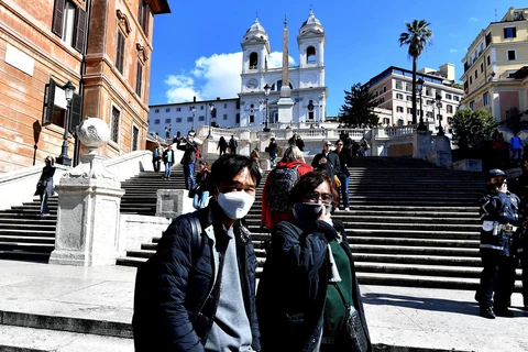 Người dân và du khách đeo khẩu trang phòng lây nhiễm COVID-19 tại Venice, Italy, ngày 8/3. (Ảnh: AFP/TTXVN)