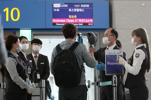 Hành khách trở về Mỹ được kiểm tra thân nhiệt nhằm ngăn chặn sự lây lan của dịch COVID-19 tại sân bay quốc tế Incheon, Hàn Quốc ngày 3/3 vừa qua. (Ảnh: YONHAP/TTXVN)