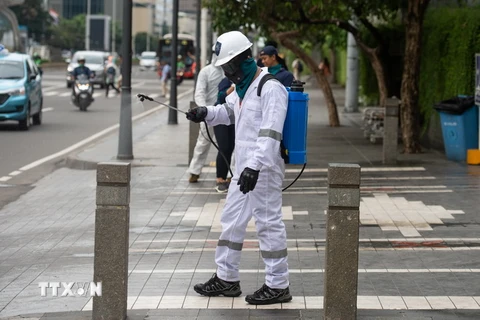 Nhân viên phun thuốc khử trùng tại địa điểm công cộng ở Jakarta, Indonesia, nhằm ngăn chặn sự lây lan của COVID-19. (Ảnh: THX/TTXVN)