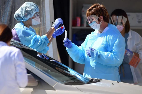 Nhân viên y tế lấy mẫu bệnh phẩm xét nghiệm COVID-19 tại San Francisco, bang California, Mỹ. (Ảnh: AFP/TTXVN)