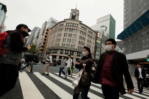 Người dân đeo khẩu trang nhằm ngăn chặn sự lây lan của dịch COVID-19 tại Tokyo, Nhật Bản ngày 28/3. (Ảnh: AFP/TTXVN)