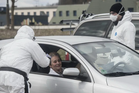 Nhân viên y tế kiểm tra thân nhiệt các tài xế nhằm ngăn chặn sự lây lan của dịch COVID-19 ở Rozvadov, Cộng hòa Séc. (Ảnh: AFP/TTXVN)
