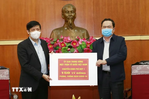 Chủ tịch Ủy ban Trung ương MTTQ Việt Nam Trần Thanh Mẫn trao tượng trưng kinh phí cho đại diện Bộ Y tế. (Ảnh: Doãn Tấn/TTXVN)