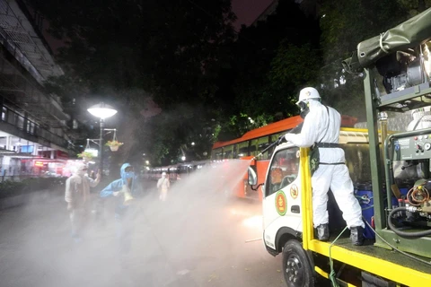 Lực lượng bộ đội hóa học phun hóa chất khử trùng, tẩy độc Bệnh viện Bạch Mai. (Ảnh: Dương Giang/TTXVN)
