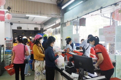 Người dân mua hàng tại một điểm bán nhu yếu phẩm thiết yếu ở thành phố Buôn Ma Thuột. (Ảnh: Tuấn Anh/TTXVN)