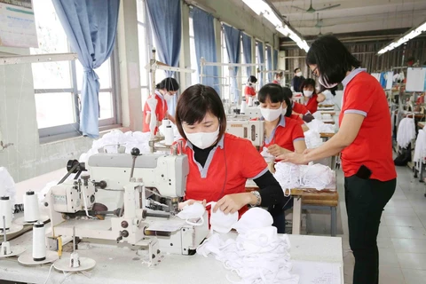 Công nhân Xí nghiệp may 1, Công ty Cổ phần May Chiến Thắng sản xuất khẩu trang vải dệt kim kháng khuẩn. (Ảnh: Phương Hoa/TTXVN)