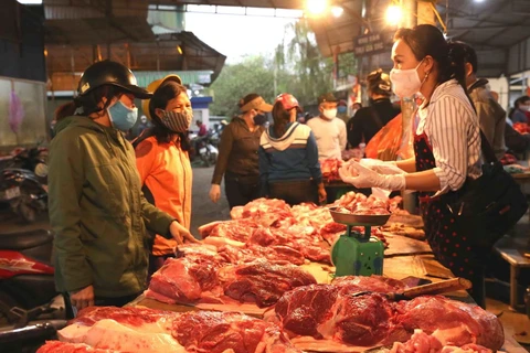 Người tiêu dùng mua thịt lợn tại chợ Phùng Khoang, quận Thanh Xuân, Hà Nội. (Ảnh: TTXVN)
