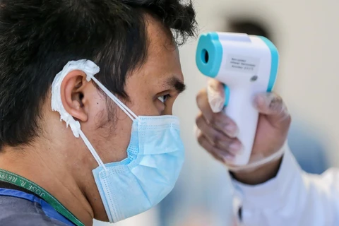 Kiểm tra thân nhiệt của người dân nhằm ngăn chặn sự lây lan của dịch COVID-19 tại Manila, Philippines ngày 7/4 vừa qua. (Ảnh: THX/TTXVN)