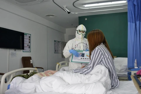 Nhân viên y tế chăm sóc bệnh nhân nhiễm COVID-19 tại bệnh viện ở Bắc Kinh, Trung Quốc. (Ảnh: THX/TTXVN)