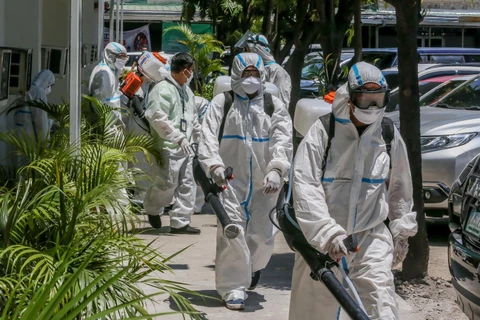 Công nhân phun thuốc khử trùng nhằm ngăn dịch COVID-19 lây lan tại Manila, Philippines. (Ảnh: THX/TTXVN)