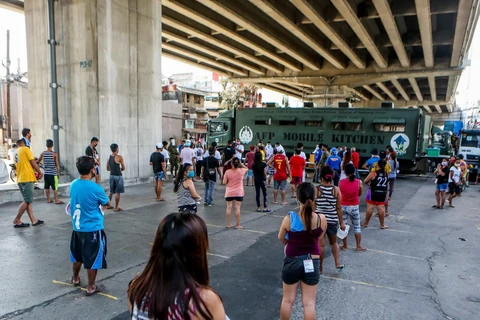 Người dân xếp hàng chờ nhận thực phẩm miễn phí tại Quezon, Philippines, ngày 20/4 vừa qua, trong bối cảnh dịch COVID-19 lan rộng. (Ảnh: THX/TTXVN)