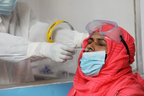 Nhân viên y tế lấy mẫu xét nghiệm COVID-19 tại bệnh viện ở Dhaka, Bangladesh. (Ảnh: THX/TTXVN)