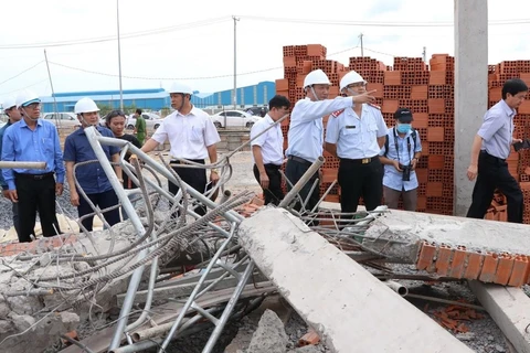 Thứ trưởng Bộ Xây dựng Lê Quang Hùng cùng đoàn công tác liên bộ kiểm tra hiện trường sập công trình xây dựng. (Ảnh: Sỹ Tuyên/TTXVN)
