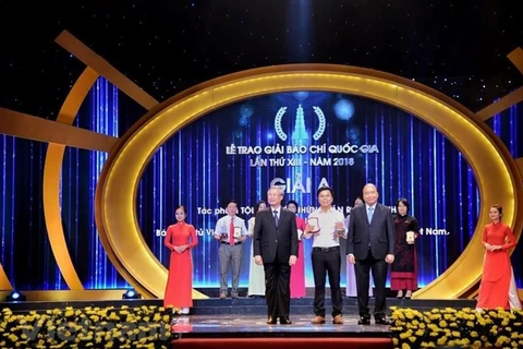 Phóng viên Võ Mạnh Hùng (Báo Điện tử VietnamPlus) nhận giải A với tác phẩm Tội ác dưới những tán rừng xanh… Cửa đóng nhưng ruột vẫn rỗng. (Ảnh: Minh Hiếu/Vietnam+)