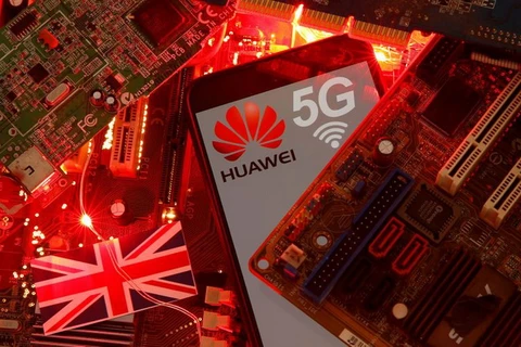 Cờ Anh và điện thoại thông minh có logo mạng Huawei và 5G. (Nguồn: Reuters)