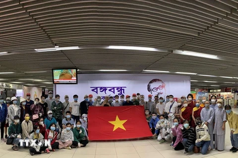 Công dân Việt Nam tại Bangladesh chuẩn bị làm thủ tục lên máy bay về nước. (Ảnh: TTXVN phát)