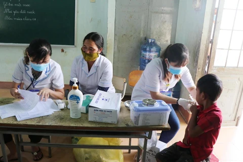 Nhân viên y tế khám sàn lọc và tiêm vắcxin phòng bệnh bạch hầu cho trẻ em dưới 7 tuổi tại buôn Diêo, xã Bông Krang, huyện Lắk, tỉnh Đắk Lắk. (Ảnh: Nguyễn Tuấn Anh/TTXVN)