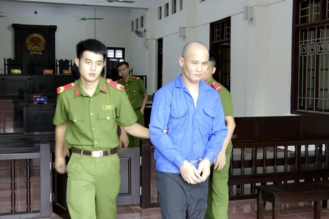 Lực lượng chức năng dẫn giải bị cáo Nguyễn Việt Bắc sau khi kết thúc phiên tòa. (Ảnh: Vũ Hà/TTXVN)