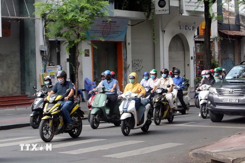 Người dân TP Hồ Chí Minh thực hiện đeo khẩu trang phòng chống dịch COVID-19 khi tham gia giao thông. (Ảnh: Thanh Vũ/TTXVN)