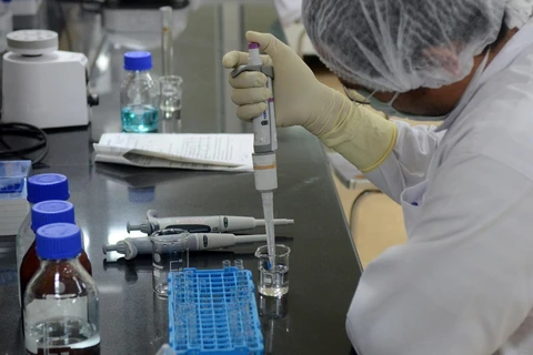 Nghiên cứu viên bào chế vắcxin phòng COVID-19 tại phòng thí nghiệm. (Ảnh: Reuters/TTXVN 