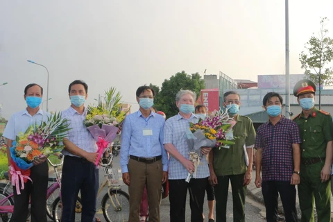 Lãnh đạo UBND thành phố Phủ Lý tặng hoa chúc mừng người dân tại tổ dân phố Đình Tràng hoàn thành thời gian cách ly y tế. (Ảnh: Thanh Tuấn/TTXVN)